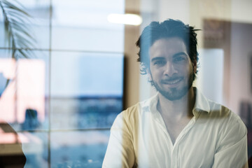 Young businessman portrait behind the office glass