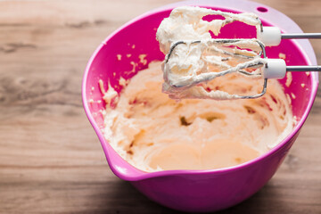 whipped butter, bowl with butter and whisk for beating on a wooden table, mixer