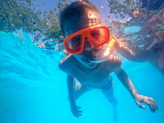 Naklejka premium A little boy dives in the pool