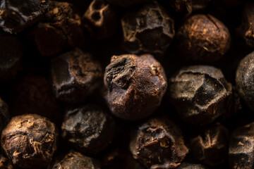 Fullscreen macro closeup with shallow depth of field of unmilled black peppercorns