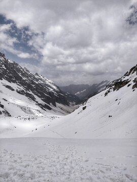 Epic panoramic view of Kullu Valley under snow in the month of June from top of Indian Himalayan Mountain peak on a Humpta pass Trek near Manali.