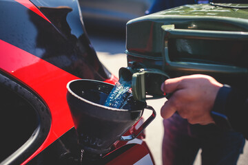 Obraz premium Process of refueling the sportcar tank with gasoline from canister during test-drive racing competition event