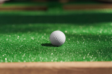 Featherie ball for golf on the green grass at sunny day. advert for golf club
