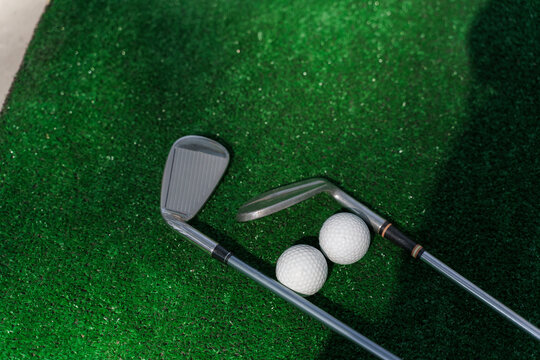 2 Niblick and 2 balls on the green grass for golf sport game.