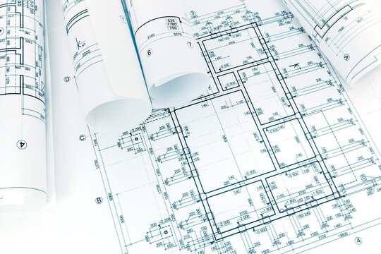 rolled building plans on architectural project blueprint background 