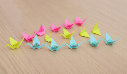 Origami cranes flocking in line