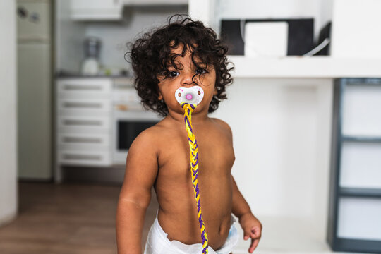 cute one year old black baby with a baby pacifier