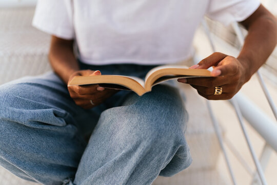 close up of a woman in blue jeans reading a book