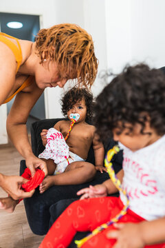 mother is dressing up the adorable twin girls