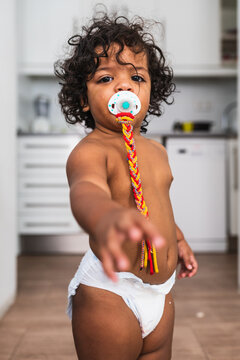 Adorable one year old girl with a baby pacifier. Close up