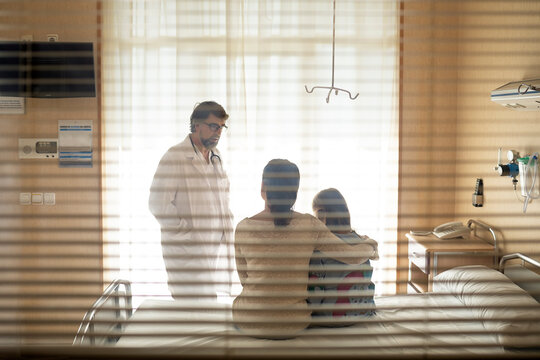 Mother and her daughter talking with the doctor about the little patient illness