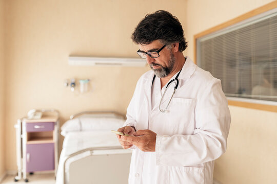 Doctor checking his phone while working in a hospital