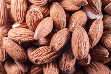 Closeup of shiny peeled almond seeds. Peeled almond texture. Superfood. Natural food.