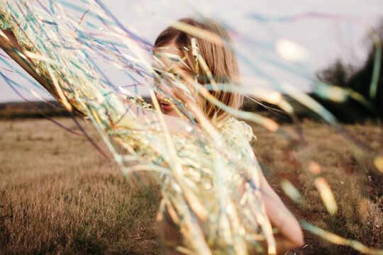Peaceful woman with shiny confetti on meadow