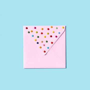 Paper handmade envelope with small colorful buttons.