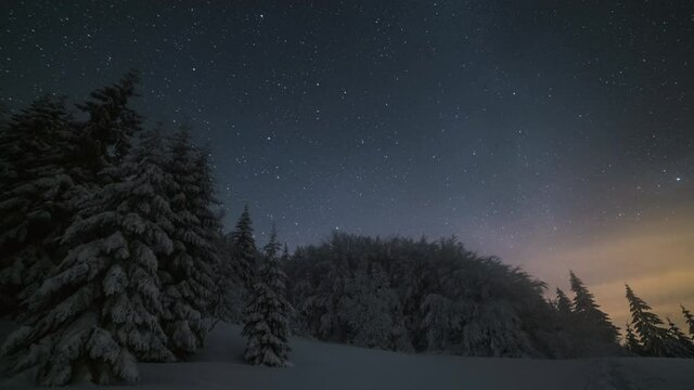 Time-lapse of the Milky Way, Jupiter, Saturn and the night sky behind a wide hill in the forest.