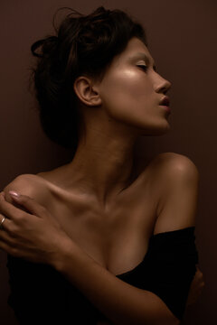 Stunning portrait of an asian girl with the hand near her face looking above
