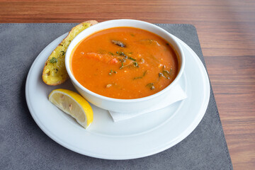 Delicious fish soup Bouillabaisse in a white plate with toasted and rosemary. A dish of traditional...