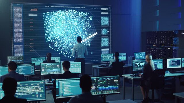 Team of Professional Computer Data Science Engineers Work on Desktops with Screens Showing Charts, Graphs, Infographics, Technical Neural Network Data and Statistics. Dark Control and Monitoring Room.