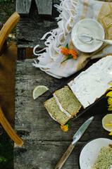Homemade lemon cake with poppy seeds and cream cheese glaze. Summer cake on a wooden table in rustic style.