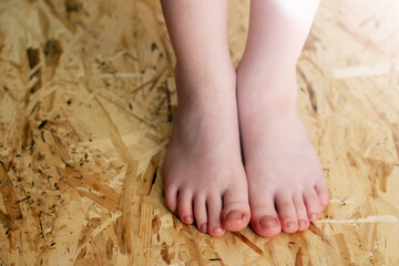 Children's feet on OSB material