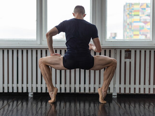 Young man training ballet at school.