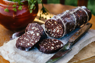 Dessert of cookies, Sweet chocolate sausage (confectionery wurst) on white plate, close up. Rustic style.