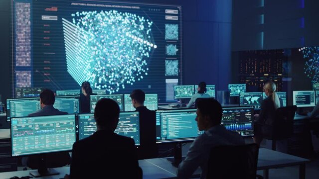 Team of Professional Computer Data Science Engineers Work on Desktops with Screens Showing Charts, Graphs, Infographics, Technical Neural Network Data and Statistics. Dark Control and Monitoring Room.