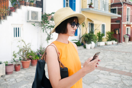 Female model with hat and sunglasses using her mobile phone on vocation