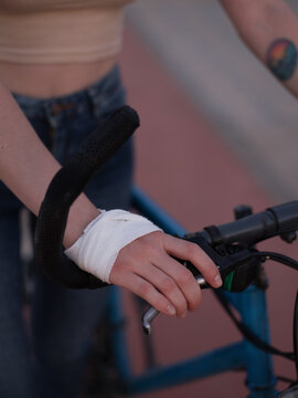 Crop injured cyclist pulling bike