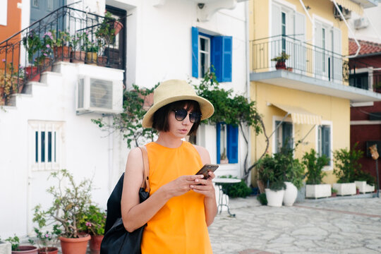 Female model with hat and sunglasses using her mobile phone on vocation