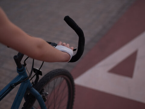 Unrecognizable injured lady riding bicycle