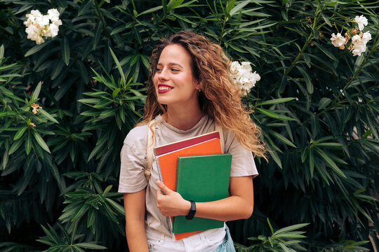 Female student carrying notebooks
