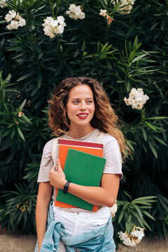 Female student carrying notebooks