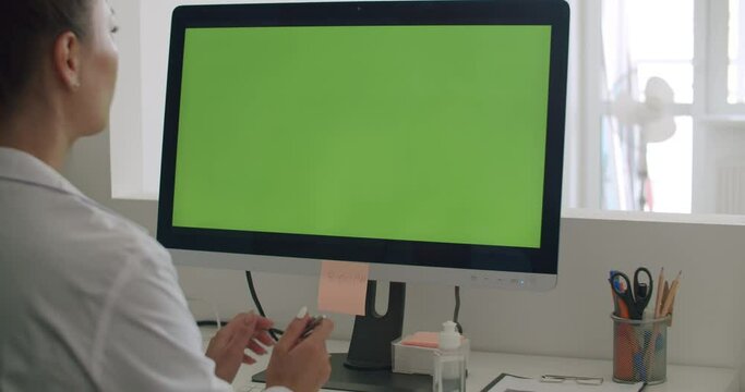 Doctor work on computer with green mock-up screen