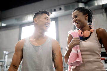 Group of young sporty people sitting on the floor against white wall