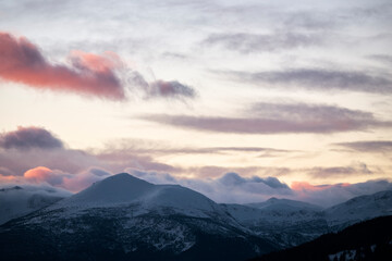 Sunset over mountains covered with snow