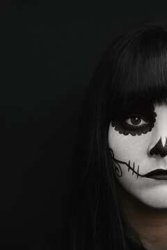 Elegant woman in Halloween black dress with sugar skull makeup