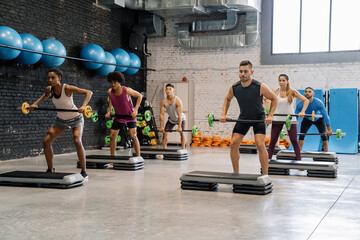 Group Of People Exercising With Barbell In Gym
