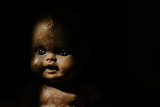 close up of a vintage baby doll, in the shadow