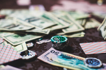 View of poker table with pack of cards, tokens, alcohol drinks, dollar money and group of gambling...