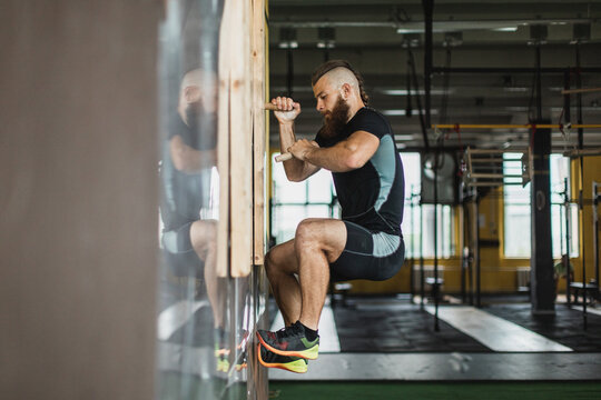 Strong and healthy man climbing inside a crossfit gym.
