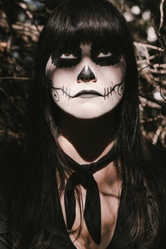 Elegant woman in Halloween black dress with sugar skull makeup
