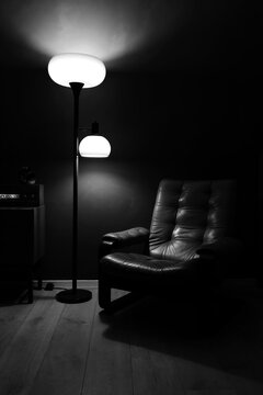 Vintage sixties leather chair and lamp in dark room