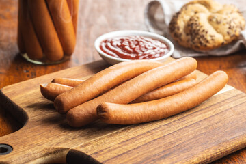 Fresh frankfurter sausages with bun and ketchup.