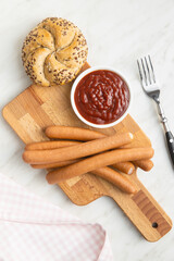 Fresh frankfurter sausages with bun and ketchup.