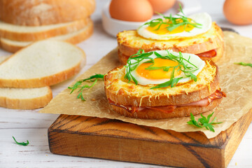 Sandwich white bread with ham or bacon, mustard, cheese, Bechamel sauce, watercress and eggs. CROQUE MADAME. traditional French cuisine. Selective focus