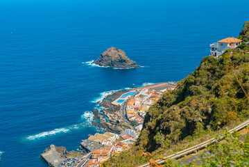 Fototapeta na wymiar Beautiful panoramic view of a cozy Garachico town on the ocean shore from the high mountain, Tenerife, Canary Islands, Spain