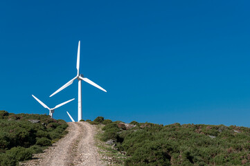 mountain landscape, with a stone road and windmills generating electric energy