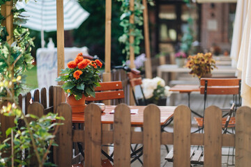 Outdoor restaurant with fresh flowers on the wooden table